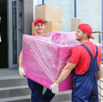 Zwei Umzugshelfer tragen ein in Folie gepacktes Möbelstück – Umzug in Pfungstadt